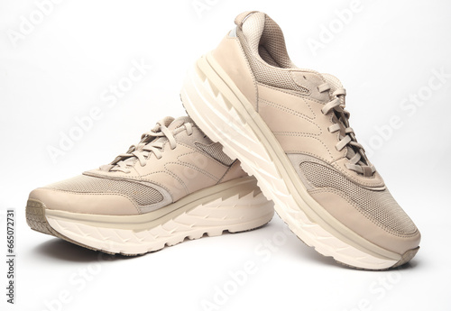 Pair of beige leather running shoes isolated on white background