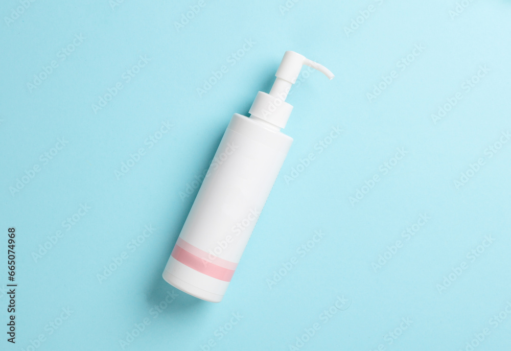 White lotion dispenser on blue background White lotion dispenser on blue background