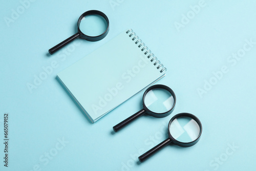 Notepad with magnifiers on a blue background. Education, business concept