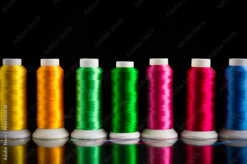 set of different color sewing threads,on black background. set of different color sewing threads,on black background.