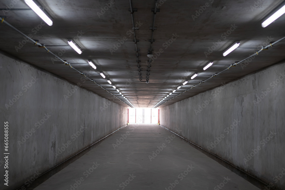Underground Parking Garage. Concrete tunnel and bright light at the destination