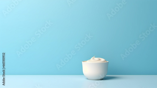 Bowl with sour cream, mayo, yogurt on soft blue background for copy space photo