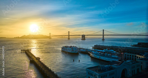 Aerial gold and blue sunrise over San Francisco Bay with Pier 7 docked boats and Oakland Bay Bridge © Nicholas J. Klein