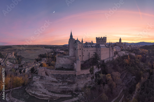 Drone view of medieval castle against sunset sky and moon photo