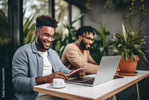 Business smiling black men in casual wear laptop while working on laptop at home office. Young men freelancers online working, telecommuting.