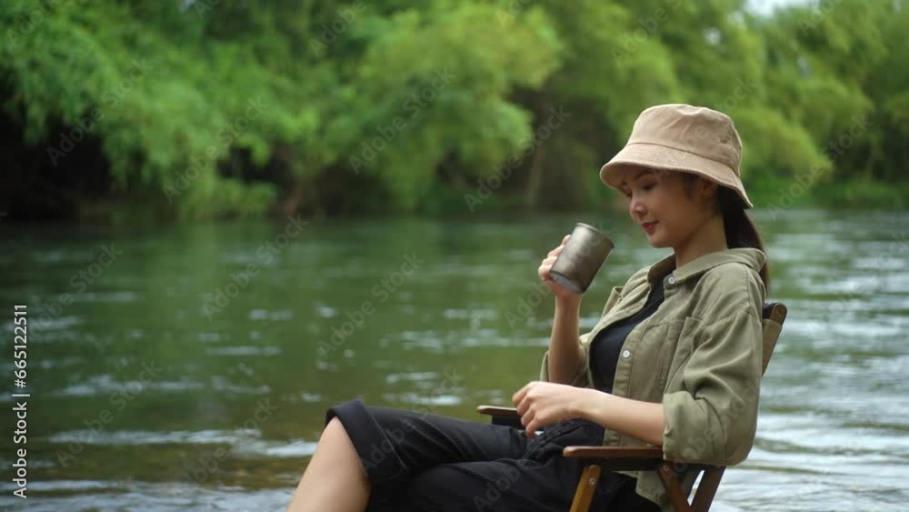 Happy woman breathing fresh air and drinking coffee near river forest campsite in the morning. Relax and vacation time with nature. Human and natural concept. Happy woman breathing fresh air and drinking coffee near river forest campsite in the morning. Relax and vacation time with nature. Human and natural concept.
