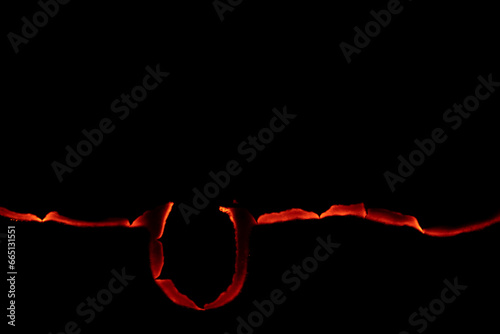 burning paper, glowing edge of paper on a black background