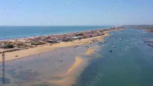 Aerial view of the ocean coast and beach. Boats on the water as seen from a drone. Praia de Faro Ria Formosa. Algarve Portugal. Bird's eye view altitude.