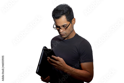 Young Latino with glasses and laptop, looking serious at his phone. Networking concept, programming, business, cybersecurity. Isolated.