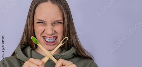 Dentist and orthodontist concept. Girl with braces cleaning teeth using brushes