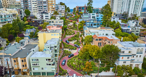 Low aerial red brick road on iconic Lombard Street with houses looking up hill