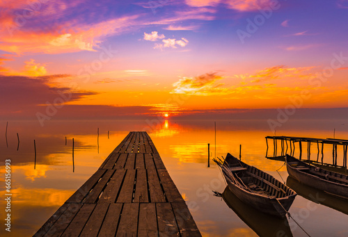 Obraz na płótnie sunrise with boats on the lake w salonie