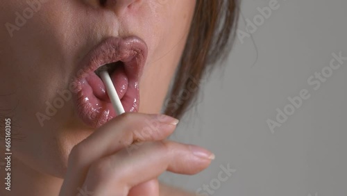 Portrait of sexy tongue licking lollipop