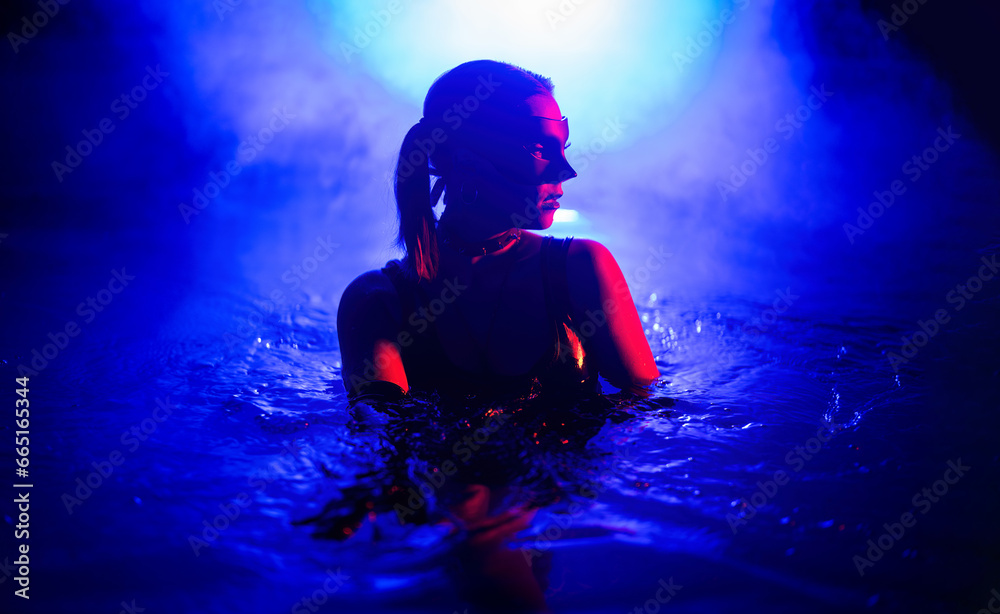 Sensual woman in leather BDSM mask dancing in swimming pool, neon light. - obrazy, fototapety, plakaty 