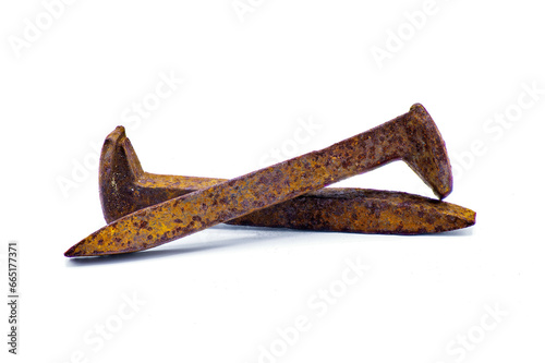 Two railroad or rail road spikes crossed showing different angles isolated on white background.  Full extreme detail throughout entire railway crutch superficial rust oxidation