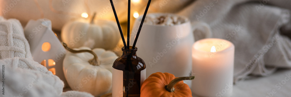 Banner. Autumn mood, cozy fall home atmosphere. Aroma diffuser, pumpkins, marshmallow chocolate hot drink, knitted warm sweaters, burning candles. Concept of house decor, apartment seasonal fragrance