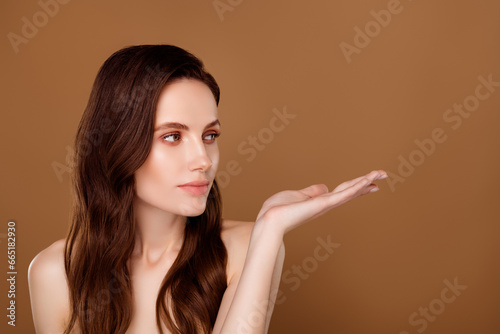 Photo of lady cosmetologist promoter hold hand showing empty space beauty products on pastel color background
