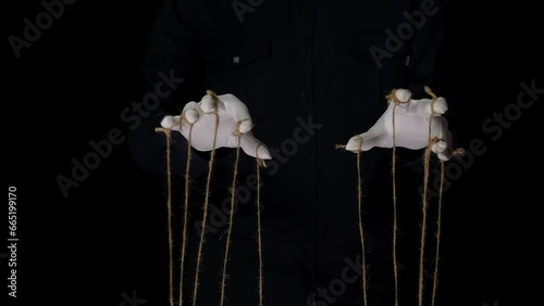 Manipulator hands in white gloves with ropes on fingers