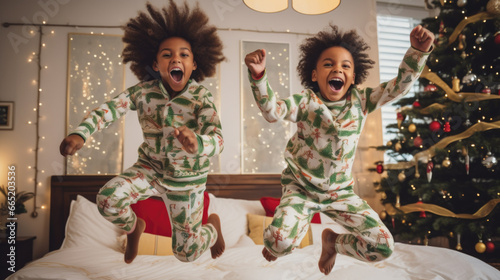 Christmas morning excitement: Happy siblings, dressed in cozy pajamas, leap with delight as they celebrate the magic of the season.