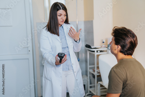 Experienced doctor checks eyes  ears  and throat of young patient in a professional clinic setting. Healthcare workers provide successful treatments.