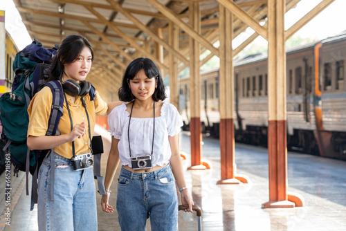 Cheerful young woman standing against train at tram station