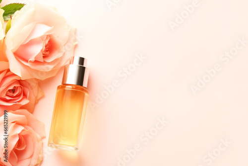 Spa relax composition with cosmetic dropper bottle with rosses oil or perfume and roses on tender pink background. Natural skin care treatment. Mock up of beauty product based on roses. Copy space