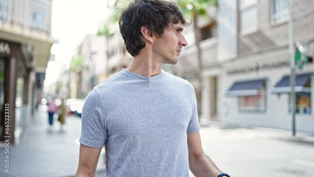 Young hispanic man looking at the watch with serious face at street Young hispanic man looking at the watch with serious face at street