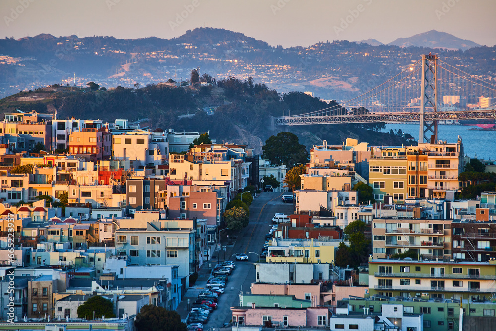 San Francisco with golden sunset light fading off buildings and Oakland Bay Bridge