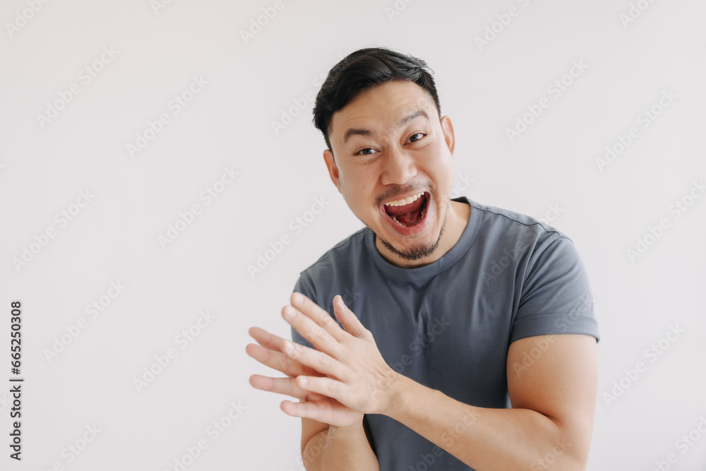 Happy asian man in blue t-shirt and jeans clapping hands stand isolated on white Happy asian man in blue t-shirt and jeans clapping hands stand isolated on white