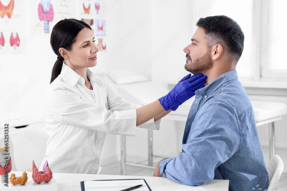 Endocrinologist examining thyroid gland of patient at table in hospital Endocrinologist examining thyroid gland of patient at table in hospital