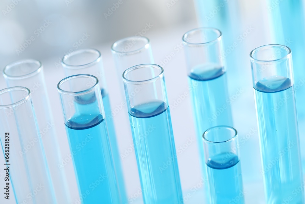 Test tubes with light blue liquid in laboratory, closeup Test tubes with light blue liquid in laboratory, closeup
