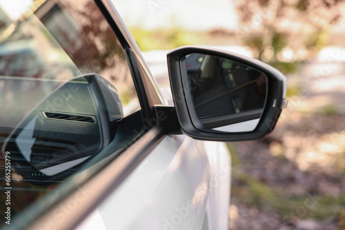 Side view mirror of modern car on blurred background, closeup © New Africa