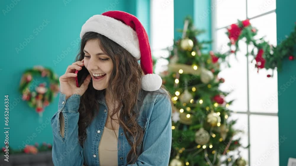 Young beautiful hispanic woman speaking on the phone celebrating christmas at home Young beautiful hispanic woman speaking on the phone celebrating christmas at home