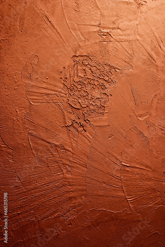 Artistic plaster trowel pattern on an orange wall with intense texture