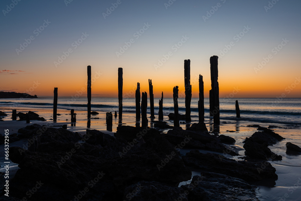 Fototapeta premium Silhouette of jetty pylons at Port Willunga, South Australia.