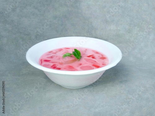 fruit soup and jelly served in bowls. pink soup. watermelon and melon ice on gray background. fresh and delicious