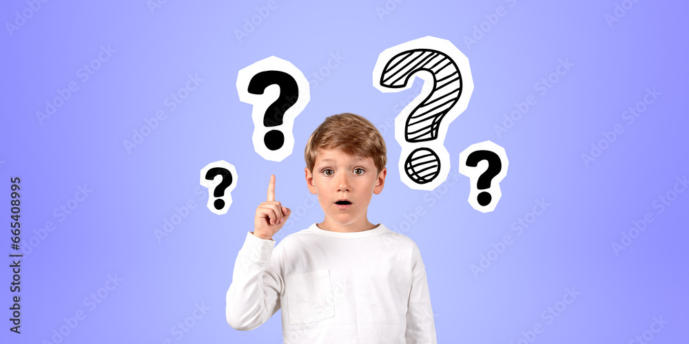 Impressed boy with finger point up at question marks on blue background Impressed boy with finger point up at question marks on blue background