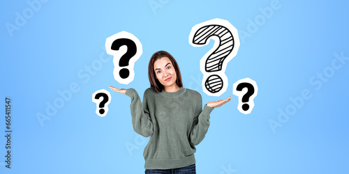 Foto Shrugging young woman and question marks