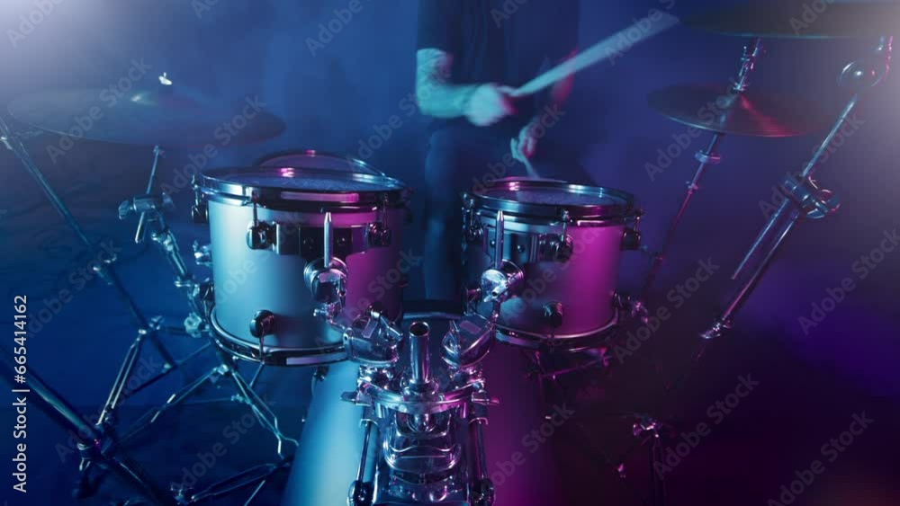 Professional Drummer Playing Drums in Studio with Neon Lighting Atmosphere.