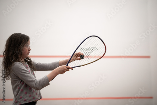 young caucasian girl racquet squash holiding ball game court win compete play strategy fun child