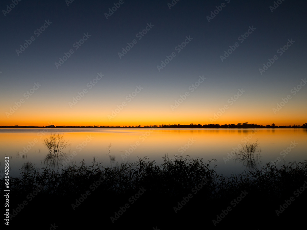 Lake with a sunset glow reflected along the horizon Lake with a sunset glow reflected along the horizon