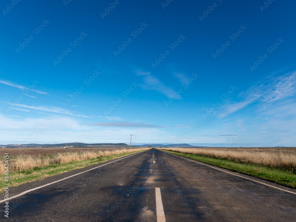 Straight tarred road disappearing into the distance Straight tarred road disappearing into the distance