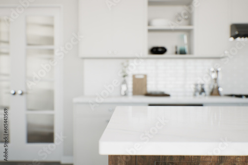 Focus on the marble countertop against the backdrop of kitchen appliances and utensils.