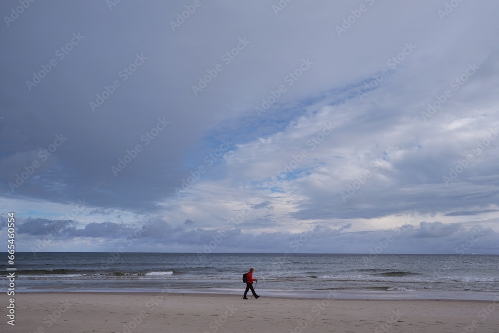 Silhouette of lonely person on beach in Hel Penisula in stormy autumn scenery. Pomerania, Poland