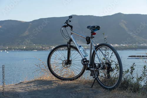 Close up bicycle on beach across mountains and blue sea and sky. High quality photo