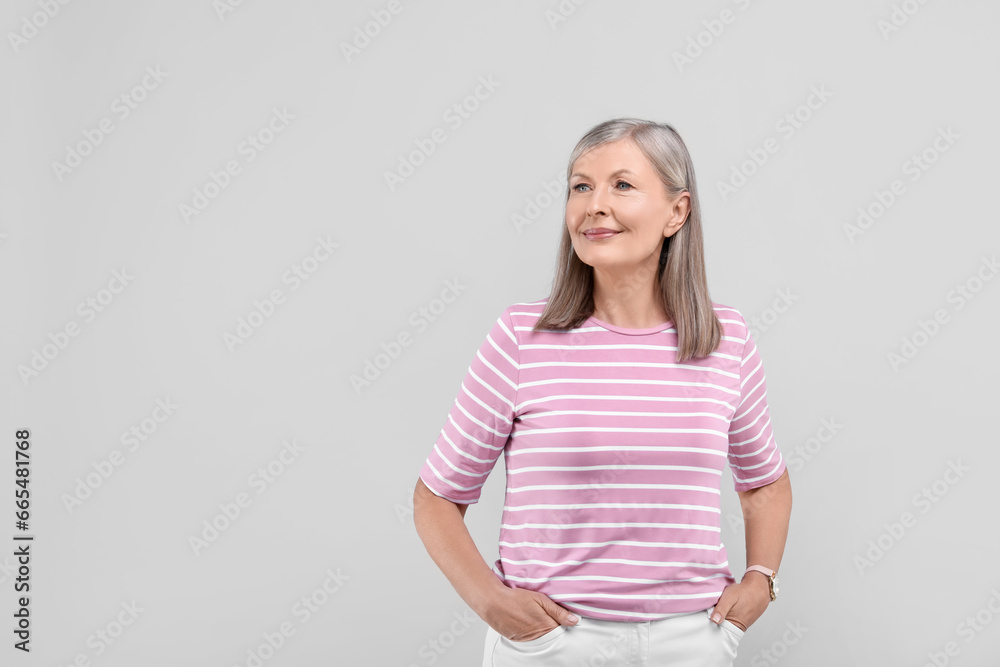 Portrait of beautiful senior woman on light grey background. Space for text Portrait of beautiful senior woman on light grey background. Space for text