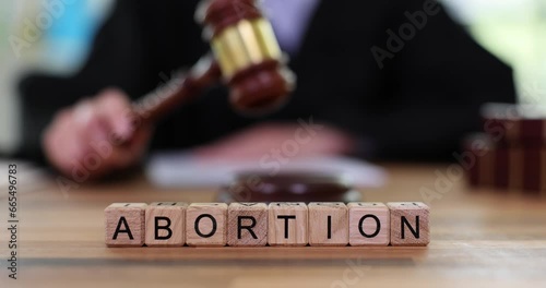 Word abortion and judge with gavel in courtroom. Ban on abortion and termination of pregnancy photo