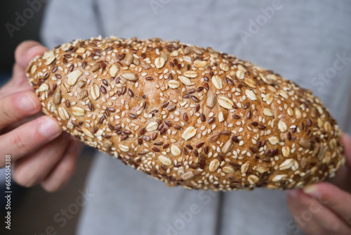hand holding a seeds wholegrain baguette