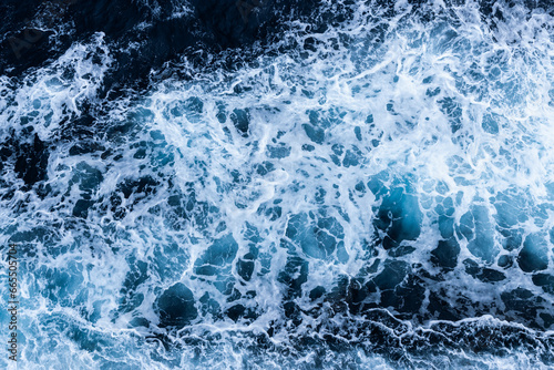 High angle view of a blue abstract background with sea foam design. Drone pointing view