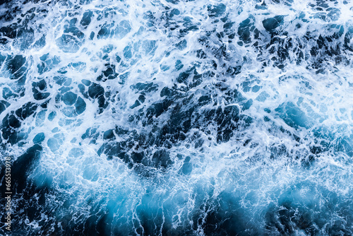 High angle view of a blue abstract background with sea foam design. Drone pointing view